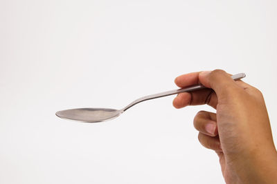 Midsection of person holding cigarette against white background