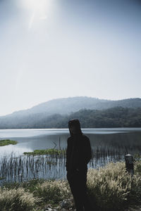 Man looking at lake against sky