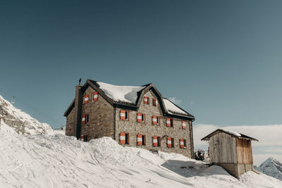 Houses on snow covered landscape against sky