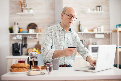 Man using laptop on table at home