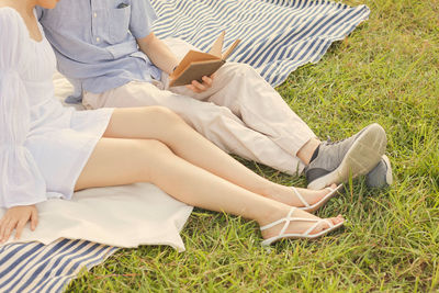 Low section of woman sitting on field