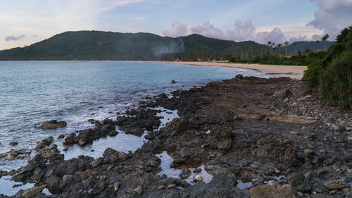 Nacpan beach volcanic rock beach near el nido, palawan, philippines clouds and smoke sunset.