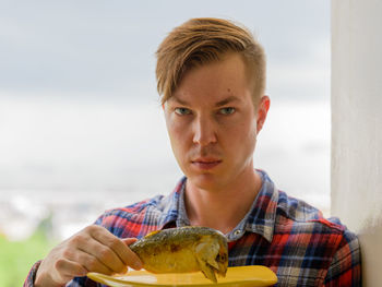 Portrait of young man holding ice cream