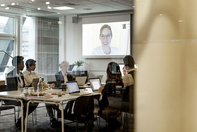 Business colleagues having meeting through video conference in board room at workplace