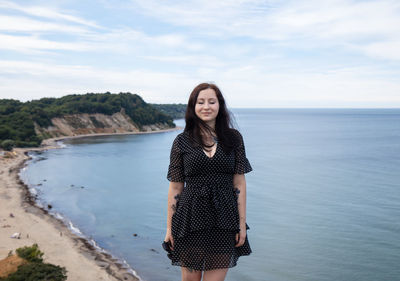 Smiling woman standing against sky