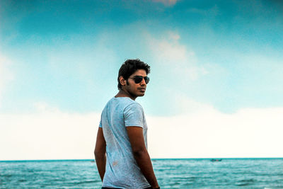 Man wearing sunglasses standing at beach