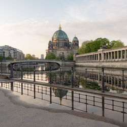 Bridge over canal amidst buildings against sky