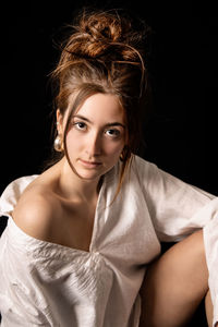 Portrait of a beautiful young woman over black background