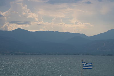 Scenic view of lake by mountains against sky