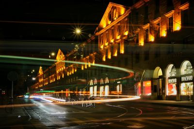 Light trails on street by building in city