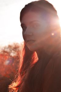 Close-up portrait of young woman against sky