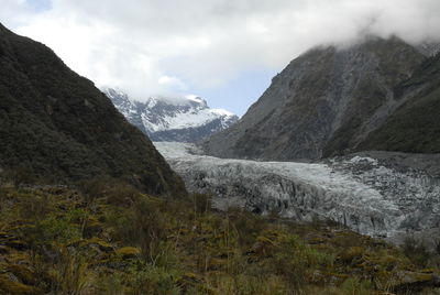 Scenic view of mountains against cloudy sky