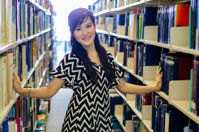 Portrait of young woman standing in library