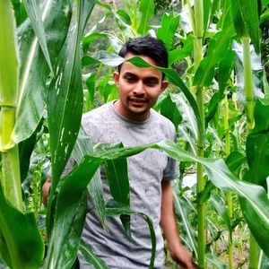 Portrait of young man standing by plants