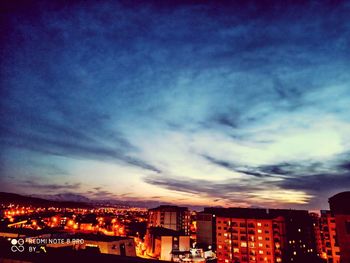 Illuminated buildings against sky at night