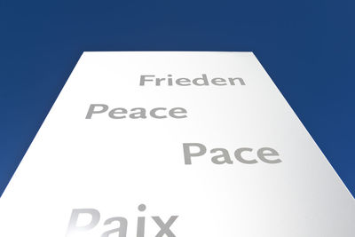 Low angle view of information sign against blue sky