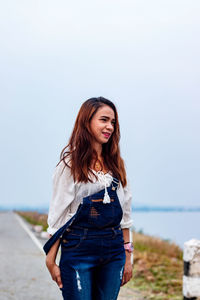 Smiling young woman standing on road