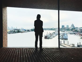 Rear view of man and woman standing at harbor