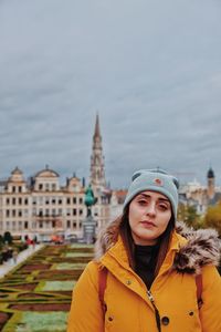 Portrait of young woman standing in city