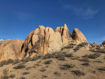 Rock formations in desert against blue sky