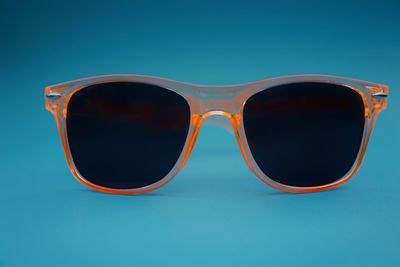 Close-up of sunglasses against blue background