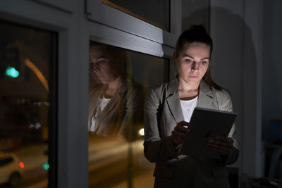 Businesswoman using digital tablet at night in office