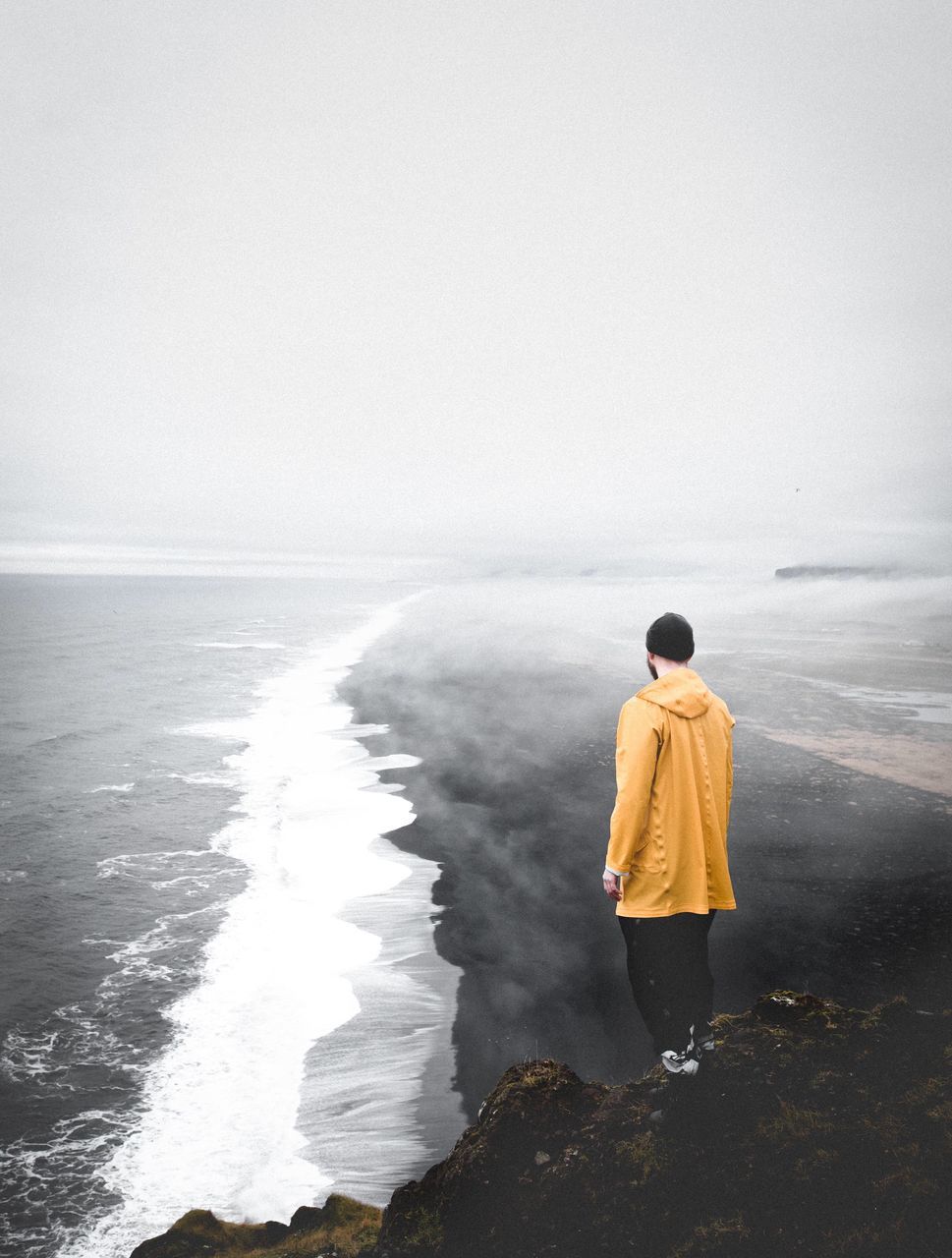 rear view, sea, one person, water, adults only, outdoors, tranquility, one woman only, adult, people, only women, full length, beach, nature, day, vacations, horizon over water, warm clothing, beauty in nature, sky, young adult