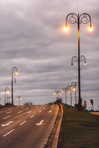 Street lights against sky at sunset