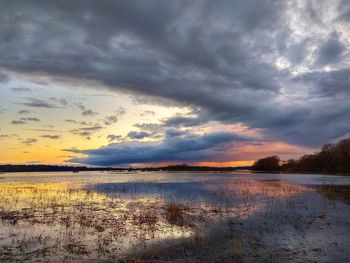 Scenic view of lake against dramatic sky