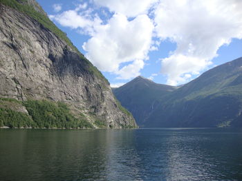 Scenic view of lake by mountains against sky