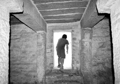 Full length rear view of man walking in building