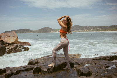 Full length of young woman standing at beach