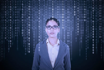 Portrait of mid adult woman against black background