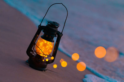 Close-up of illuminated light bulb on table