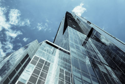 Low angle view of modern glass building against sky