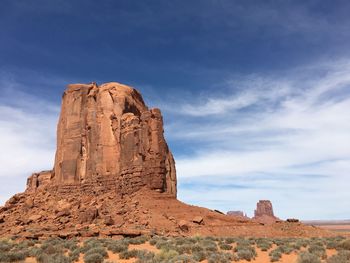 Rock formations on landscape against cloudy sky