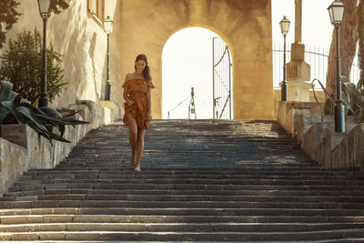 Low angle view of woman walking on staircase of building