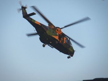 Low angle view of helicopter flying against clear sky