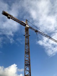 Low angle view of crane against sky