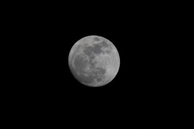 Low angle view of full moon against clear sky at night