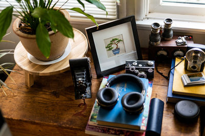 Assorted belongings on wood surface inside home near window light