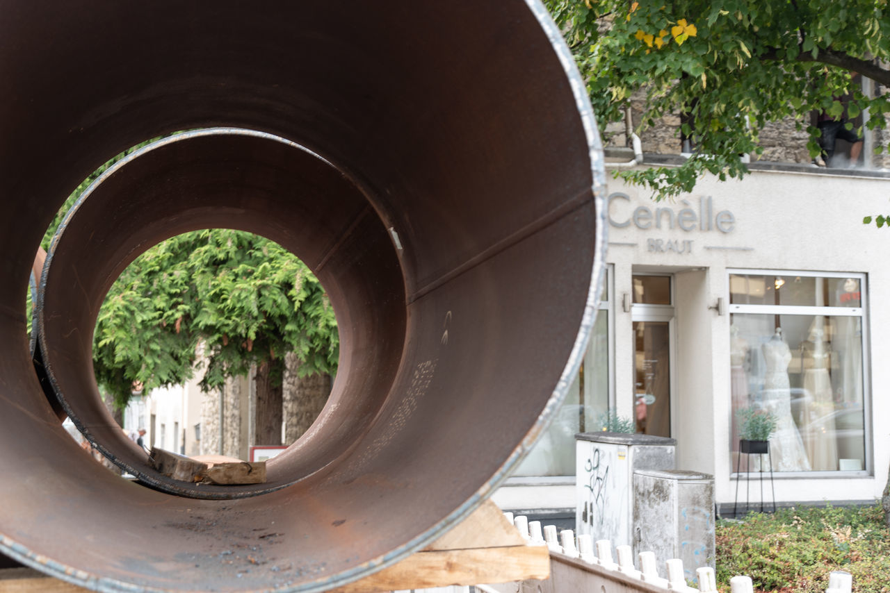 built structure, architecture, plant, day, no people, tree, nature, focus on foreground, building exterior, outdoors, pipe - tube, close-up, metal, front or back yard, shape, circle, water, window, geometric shape