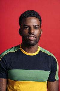 Portrait of young man against red background