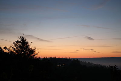 Silhouette trees against sky at sunset