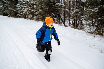 Rear view of woman skiing on snow covered field