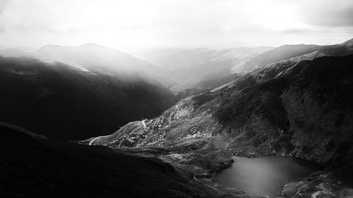 Scenic view of river amidst mountains against sky