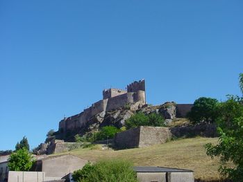 Low angle view of castle against clear blue sky