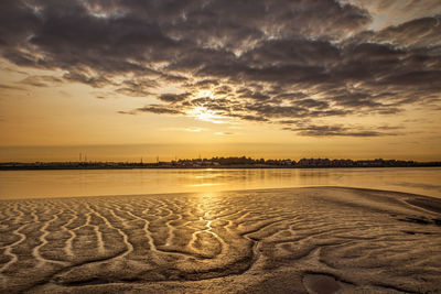 Scenic view of beach against romantic sky at sunset