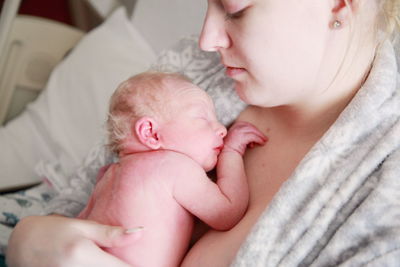 Mother holding newborn in hospital