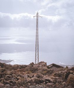 Low angle view of telephone pole against sky